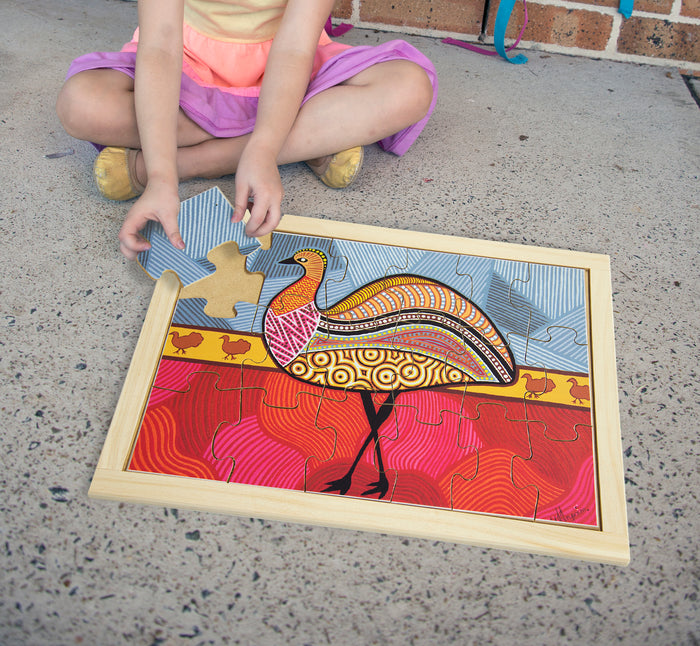 Young girl playing with 'aboriginal art emu' wooden jigsaw puzzle